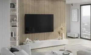 Nowoczesny salon z telewizorem wiszącym na ścianie pokrytej pionowymi lamelami. To właśnie te lamele tworzą unikalny efekt wizualny.