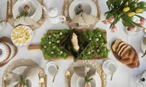 Inspiracja, jak ozdobić stół wielkanocny: mech, pisanki, babka i bukiet tulipanów tworzą wiosenną aranżację.