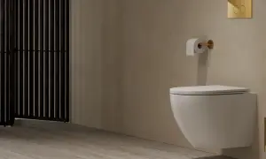 Nowoczesne wc w rogu łazienki, z podwieszanym bidetem i złotymi akcentami. Obok czarny, ażurowy parawan.