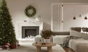 Jak udekorować salon na Boże Narodzenie? Choinka, prezenty, wianek na kominku i świece tworzą przytulną atmosferę.