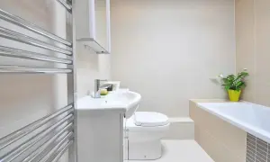 Nowoczesna łazienka z **wc bez kołnierza**, wanną i umywalką. Czystość i minimalizm.