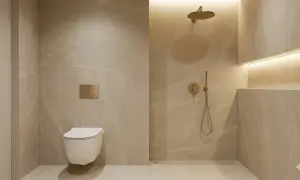 Nowoczesna łazienka z podwieszaną toaletą i złotym przyciskiem spłuczki. Obok prysznic z deszczownicą i ukrytym **kranem w ścianie**.