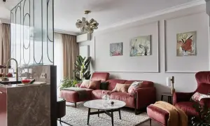Elegancka ściana w salonie z sofą w kolorze cegły, obrazami i designerską lampą.