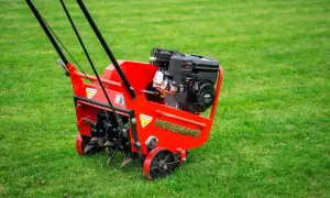 Czerwony aerator WEIBANG na zielonej trawie. Idealny moment, kiedy robić aerację trawnika, by zapewnić mu zdrowy wygląd.