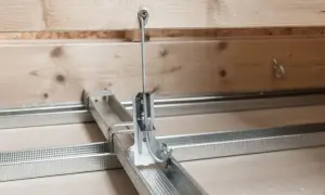 Metalowe profile i wieszaki do sufitów podwieszanych, gotowe do montażu.