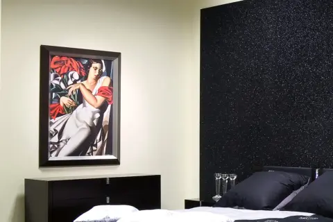 Elegancka sypialnia z obrazem i czarną ścianą inspiracje.