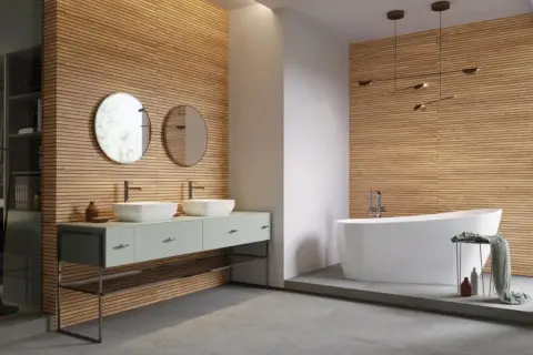 Nowe inspiracje: jakie lamele do łazienki? Drewniane panele tworzą ciepłą atmosferę, idealnie komponując się z nowoczesną wanną i podwójną umywalką.