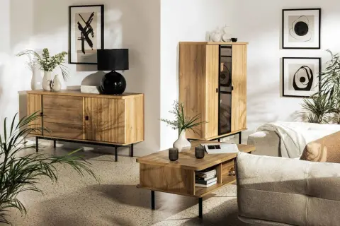 Przytulny salon inspiracje: drewniane meble, czarna lampa, wazony, obrazy i rośliny tworzą ciepłą atmosferę.