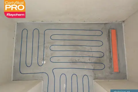 Niebieski kabel ogrzewania podłogowego pod prysznicem, gotowy do zalania wylewką. Certyfikat PRO Raychem.