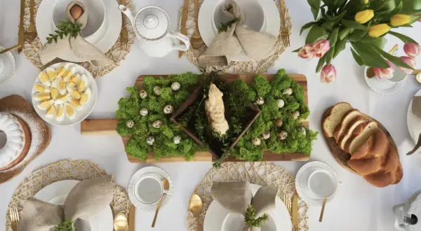 Inspiracja, jak ozdobić stół wielkanocny: mech, pisanki, babka i bukiet tulipanów tworzą wiosenną aranżację.