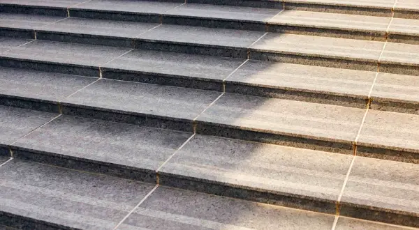 Precyzyjne układanie płytek na schodach, tworzące elegancką i trwałą nawierzchnię.