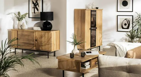 Przytulny salon inspiracje: drewniane meble, czarna lampa, wazony, obrazy i rośliny tworzą ciepłą atmosferę.