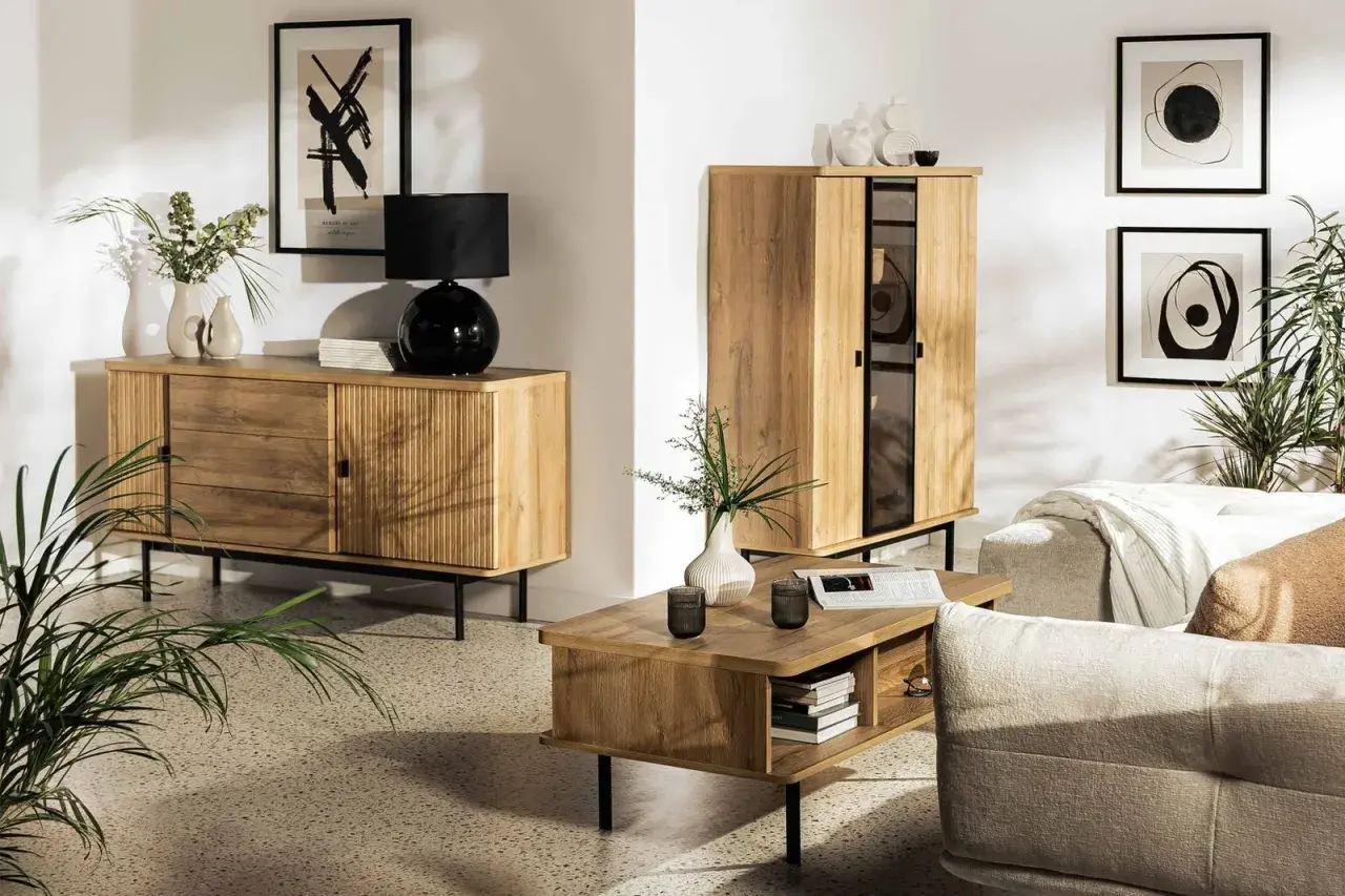Przytulny salon inspiracje: drewniane meble, czarna lampa, wazony, obrazy i rośliny tworzą ciepłą atmosferę.