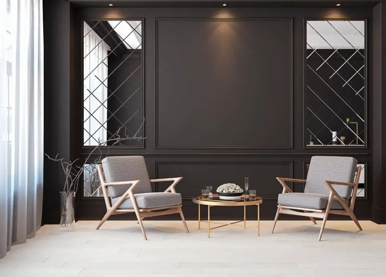 Eleganckie fotele i stolik kawowy przy czarnej ścianie inspiracje. Lustra w geometryczne wzory dodają głębi.