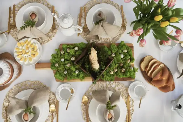 Inspiracja, jak ozdobić stół wielkanocny: mech, pisanki, babka i bukiet tulipanów tworzą wiosenną aranżację.