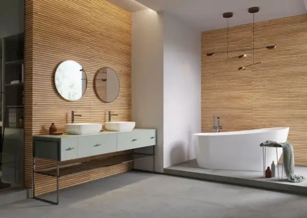 Nowe inspiracje: jakie lamele do łazienki? Drewniane panele tworzą ciepłą atmosferę, idealnie komponując się z nowoczesną wanną i podwójną umywalką.