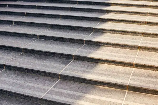 Precyzyjne układanie płytek na schodach, tworzące elegancką i trwałą nawierzchnię.