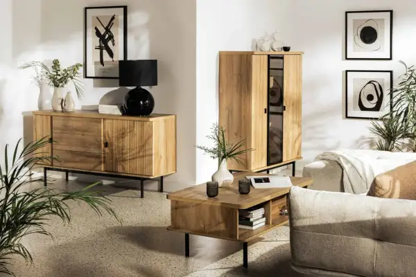 Przytulny salon inspiracje: drewniane meble, czarna lampa, wazony, obrazy i rośliny tworzą ciepłą atmosferę.